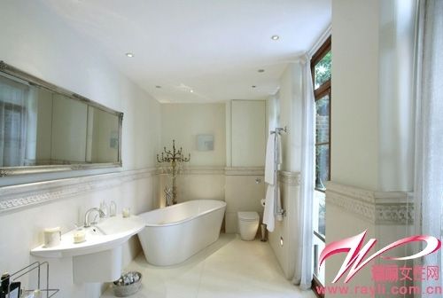 浴室里精美的腰线和浴缸旁的一盏复古水晶落地灯让纯白的浴室看起来浪漫、惬意